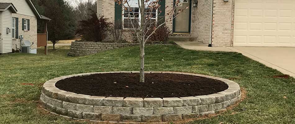 Retaining wall and mulch installation around a tree in Columbia, IL.
